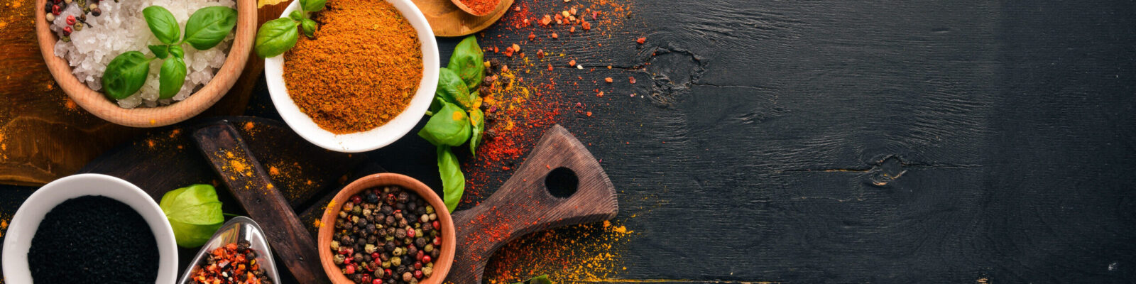 Spices and herbs on a wooden board. Pepper, salt, paprika, basil