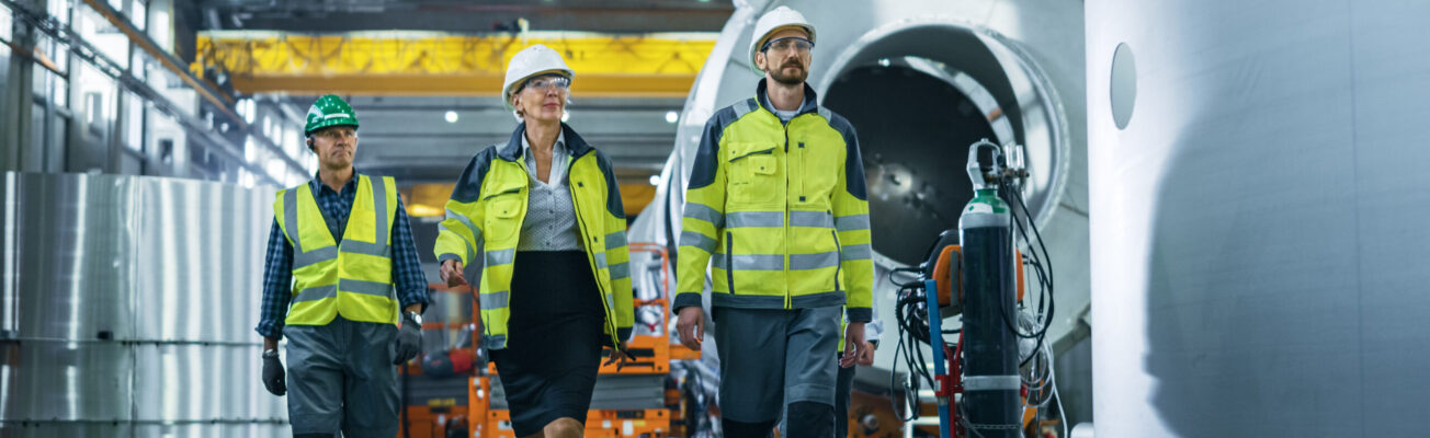 Team of Heavy Industry Engineers and Workers Walking through Pip
