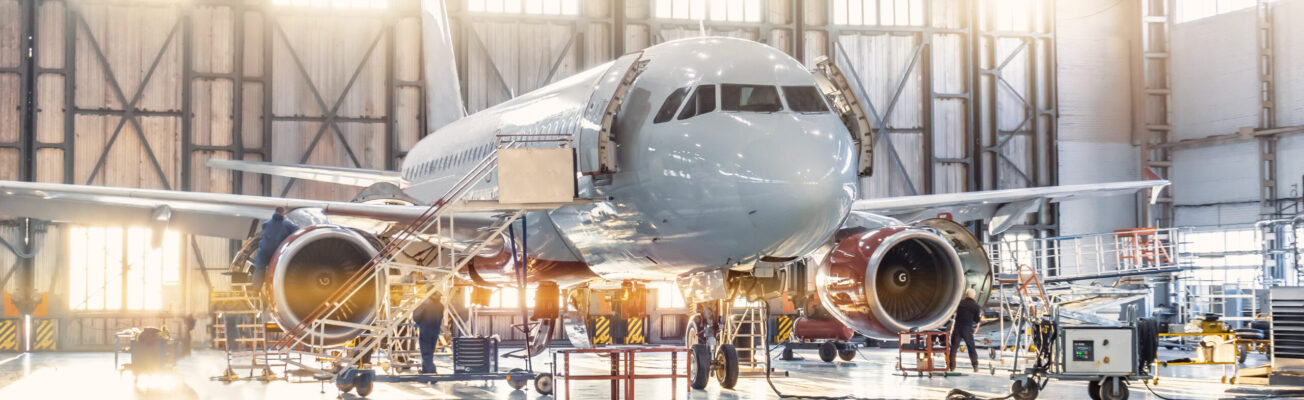 View inside the aviation hangar, the airplane mechanic working around the service.