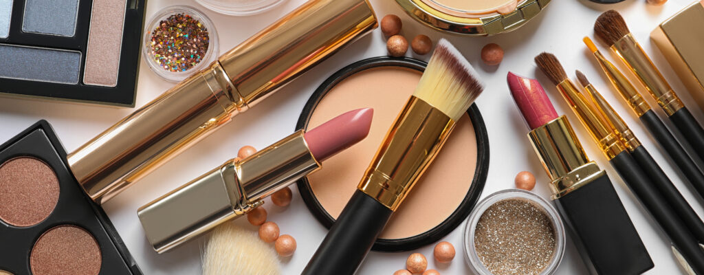 Different luxury makeup products on white background, top view