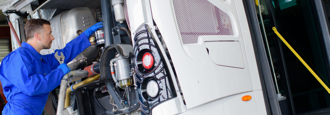 Mechanic working on engine of public transport bus